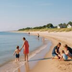 Solrik dansk strand med rolig sjo og badende barnefamilier en varm sommerdag