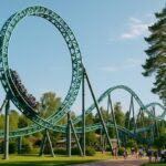 Grønn berg-og-dal-bane med loop i en sommergrønn fornøyelsespark, illustrasjon til Djurs Sommerlands nye attraksjon Midgårdsormen